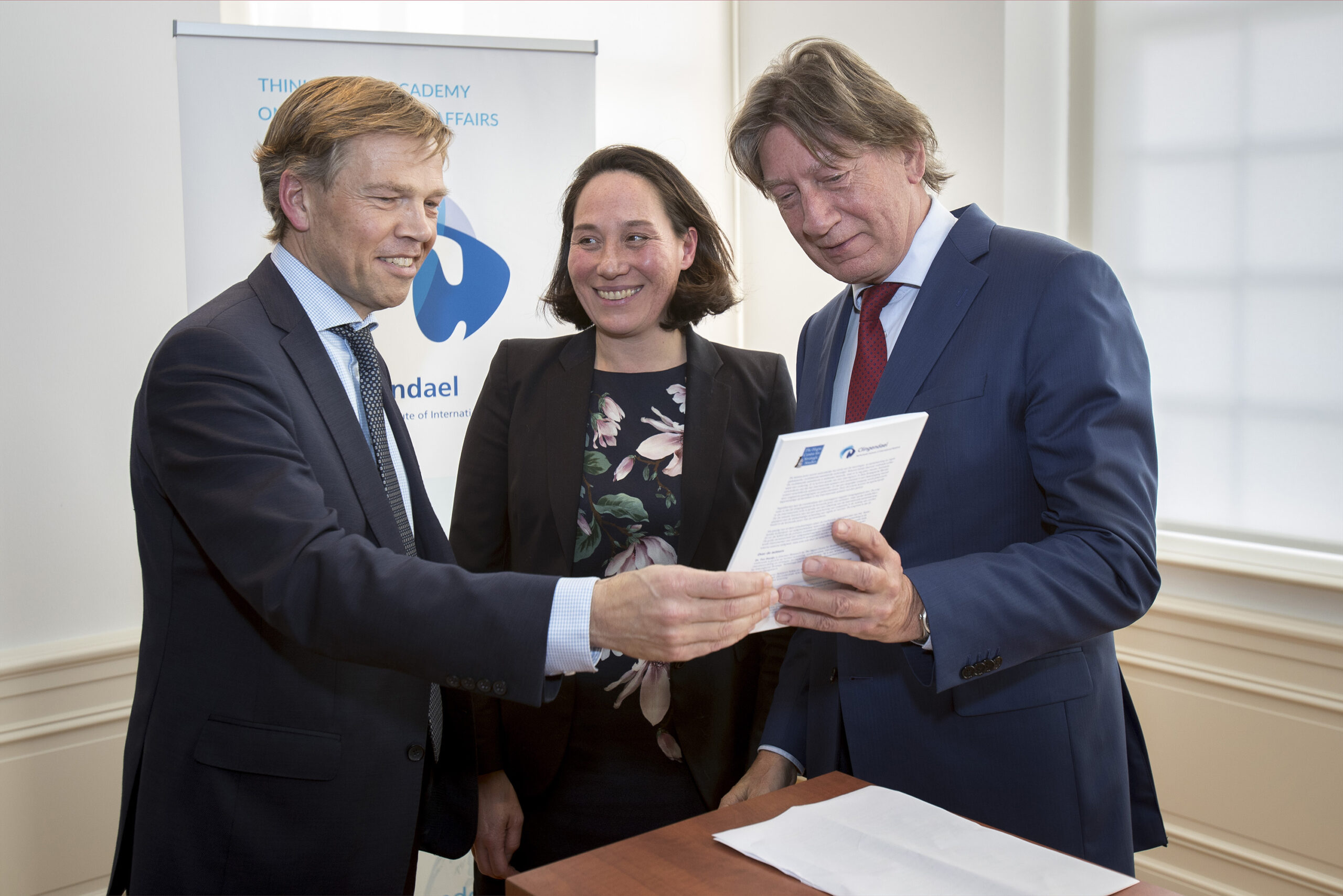 Joep Wijnands (l) neemt het rapport in ontvangst. Naast hem de directeuren Monika Sie Dhian Ho (Clingendael) en Rob de Wijk (HCSS). (foto: Defensie)